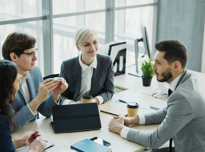 Equipo de profesionales de COOPCASA reunidos alrededor de una mesa de trabajo